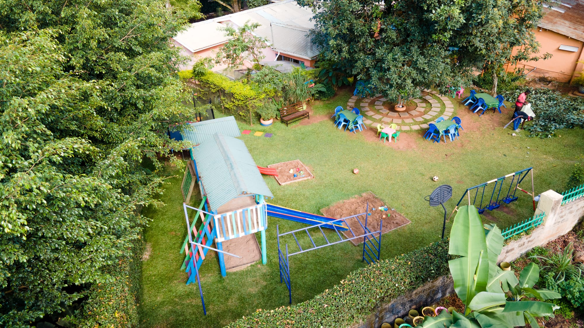 Aerial view of the KaraSpace play garden — slides, climbing frames and sandpits ringed by trees