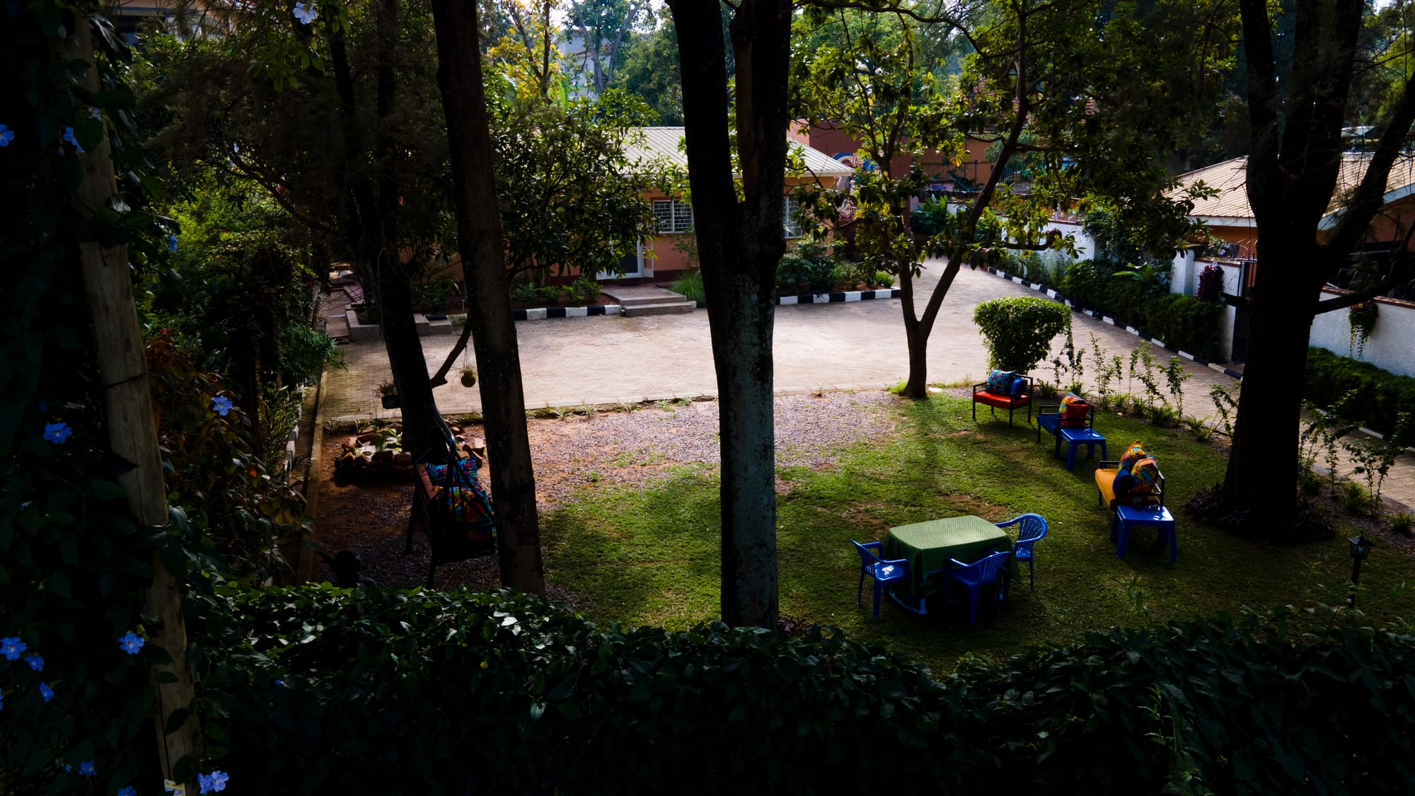 Tables and chairs set out across the lawn under the trees at dusk