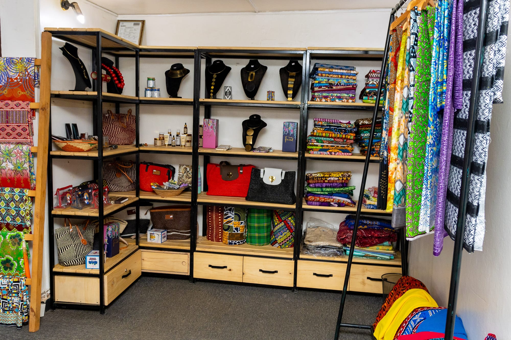 A wide view of the KaraSpace boutique — shelves of jewellery, bags, folded fabrics and a rail of bright garments