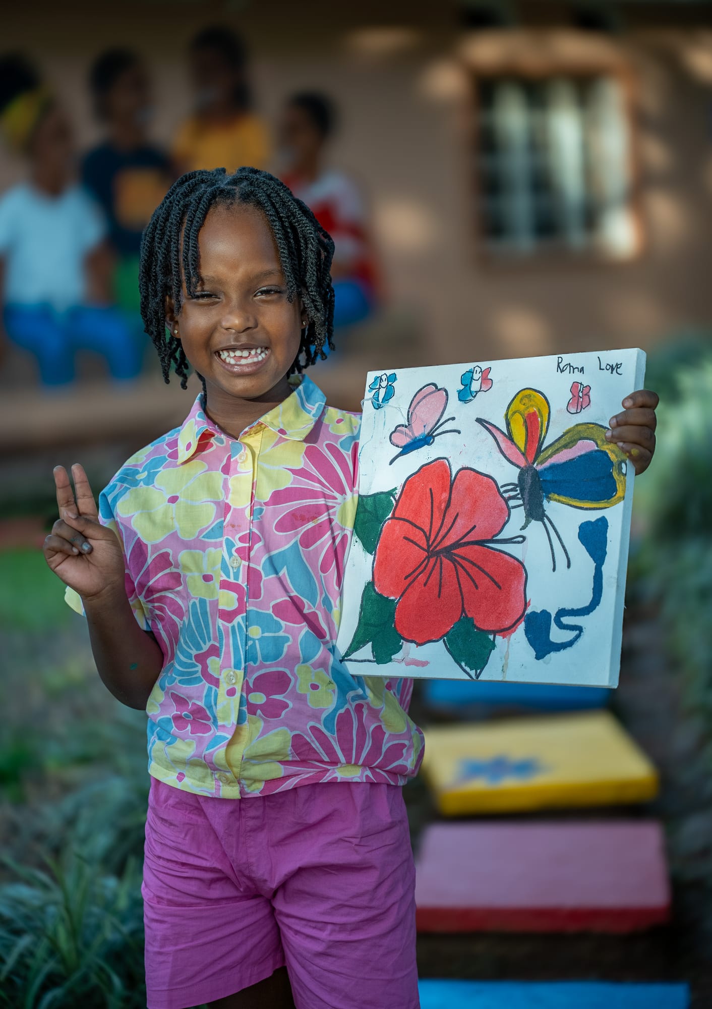 A smiling girl holding her hibiscus and butterfly canvas