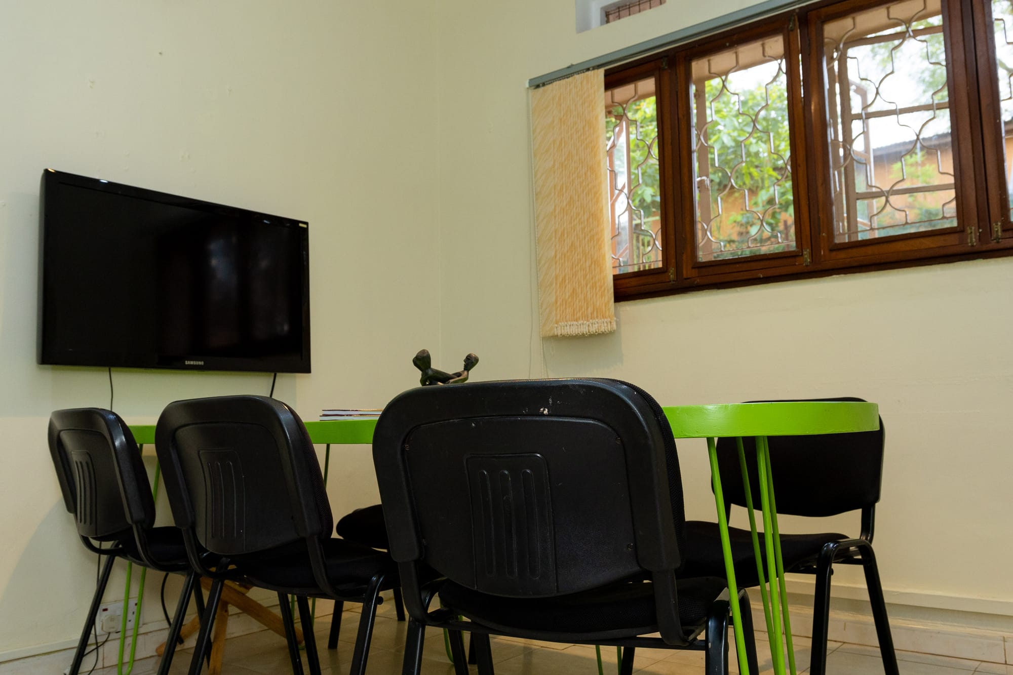 The meeting room's wall-mounted screen above the green table