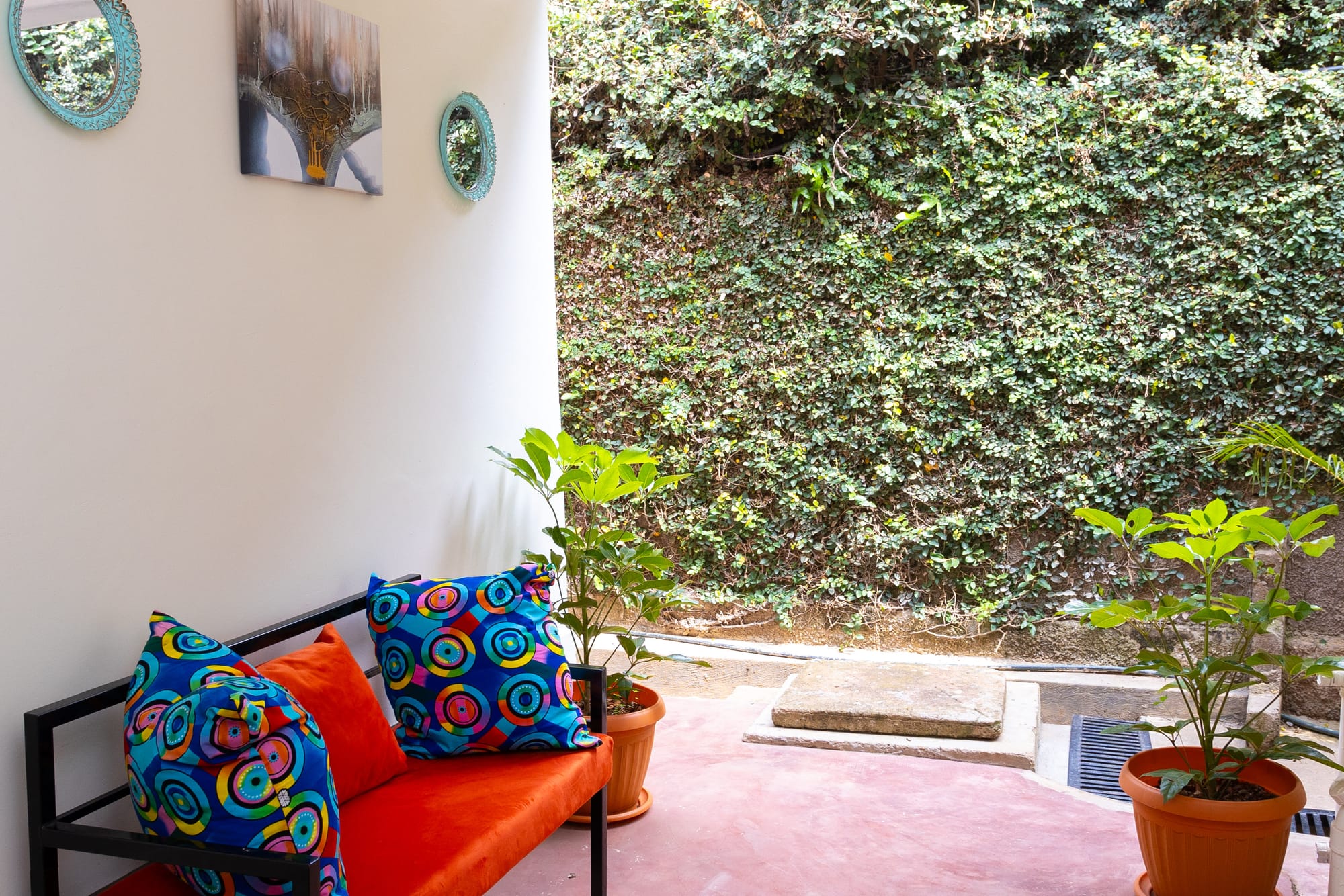 Standard Room — the made bed seen from above with bold African print pillows
